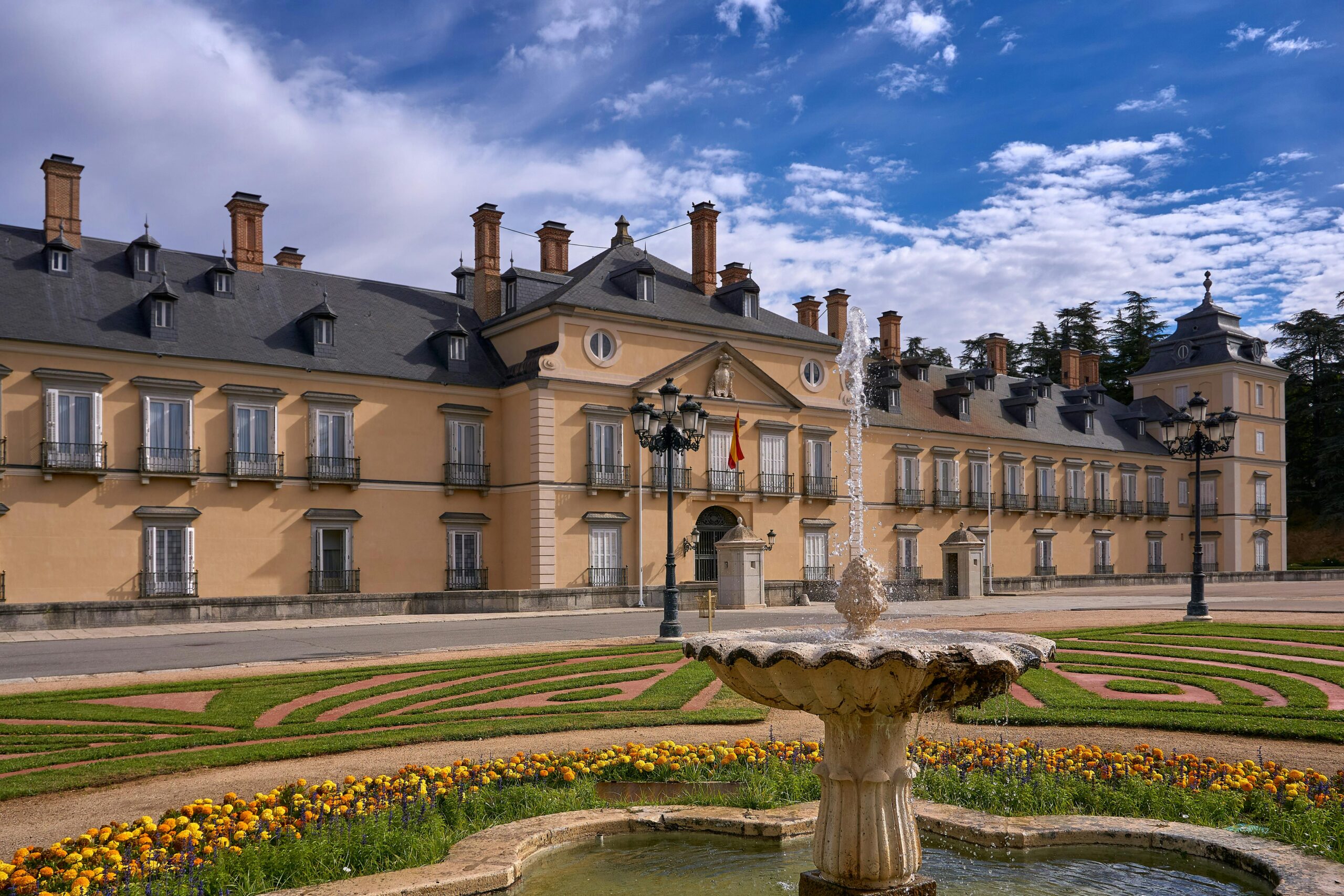 View of El Pardo Royal Palace with a fountain in the foreground on a bright day in Madrid, Spain.